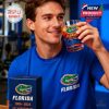 Person sipping from a Florida Gators whiskey glass, smiling with a gym background.