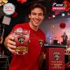 Florida Panthers fan smiling and holding up the anniversary whiskey glass in a festive indoor setting with stage lighting and decor!