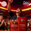 A fan raises the iconic Georgia Bulldogs whiskey glass above the crowd, filled with icy red drink, with the team’s legacy and pride engraved on both the glass and box!