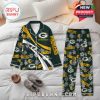 Customizable Packers-themed pajamas placed on a neatly made bed, with floral and logo prints, styled for fans who want to relax in their favorite team's colors while staying comfortable and warm!