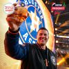 An Astros supporter lifts the commemorative glass high at the stadium, showcasing team pride and celebration for 60 iconic years!
