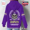 Woman modeling purple JMU hoodie from the back with skull helmet graphic and slogan!