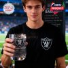 Man holding Raiders 65th Anniversary glass while wearing team shirt at stadium!