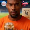 A man stares into the camera with intensity while holding a Long Beach whisky glass featuring wave art and the bold LB logo in front of a sports field!
