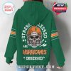 Woman modeling green hoodie from the back, featuring Miami Hurricanes skull helmet design with