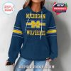 Woman wearing Michigan Wolverines hoodie from the front with classic school branding and striped sleeves!