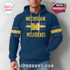Man modeling navy Michigan Wolverines hoodie with bold team graphics and comfortable waffle-knit style!