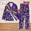 Purple Vikings-themed pajamas with white floral graphics and team logos, laid out on a wood-textured background!