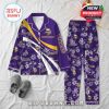 Purple Minnesota Vikings pajamas with floral patterns and team logos, arranged on a bed with cozy props nearby!