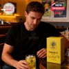 A Nashville SC fan sitting at a bar with a themed whiskey glass and collector’s box on the table!
