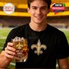 Man in Saints shirt holds a whiskey glass with 