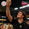 Man holds up a whiskey glass with 'Who Dat' and fleur-de-lis design, plus 'New Orleans Saints' on the box.!