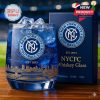 A blue NYCFC whiskey glass showing the club’s logo and a golden city skyline design. The collector box next to it includes the same crest and “NYCFC Whiskey Glass” text!