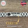 Detail view of silver Fighting Irish bracelet laying flat, showing logo, text, and name engraving space with wooden texture underneath!