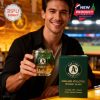 Fan enjoying a drink with an Oakland Athletics 125th anniversary glass at a stadium bar with team-themed decor.
