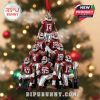 Nine Oklahoma football players form a pyramid in this festive tree ornament. The players wear red jerseys and white pants, with a trophy at the base and a red hanging ribbon at the top. Background shows a decorated Christmas tree!