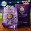 Purple Orlando City SC whiskey glass with lion crest ice cubes decorative icons and matching gift box on wooden table!