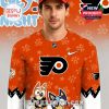 Orange hockey fan shirt with cartoon dogs paw print pattern and bold sports logo worn by a male model in studio setting!