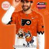 Smiling model wearing orange cartoon hockey shirt and matching cap with playful character artwork!