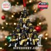 Football-themed ornament of Pittsburgh players in black and gold uniforms stacked in a pyramid, hanging on a Christmas tree.
