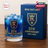 A Real Salt Lake whiskey glass filled with blue liquid and ice cubes, featuring the 21st Anniversary branding, with the packaging box displayed next to it.