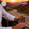 Close-up of man holding Route 66 whiskey glass by car door overlooking a winding road at sunset!