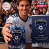 A happy man in a white San Jose Earthquakes jersey holds a blue whiskey glass filled with ice. The crowd cheers in the background while the matching product box sits beside him!