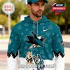 A man wearing a teal San Jose Sharks hoodie with Bluey characters and subtle patterned details in a sporty outdoor setting!
