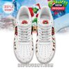 Top view of white sneakers with The Grinch Christmas pattern and festive decorations.