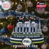 Ornament of three Seahawks players standing together with arms around each other, set against a city skyline on a Christmas tree.