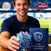 A happy supporter holds the vibrant blue Sporting KC whiskey glass at the stadium, capturing the spirit of soccer and celebration!