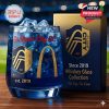 A St. Louis City SC-themed whiskey glass with gold detailing and iconic city landmarks beside a blue and gold box.