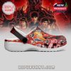 A vivid red clog with character figures and graphics from Stranger Things, viewed from the right side, highlighting artistic detail!