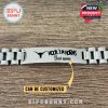 Stainless steel Hook Em Horns bracelet with engraved logo and personalized name displayed on wooden background.