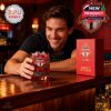 Fan at bar holding Toronto FC whiskey glass with limited edition packaging visible on the counter.