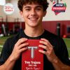 A Troy Trojans supporter smiles while holding a red collector box in an indoor sports space!