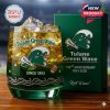 Commemorative Tulane whiskey glass with mascot logo, anniversary dates, and detailed wave patterns, shown with a themed gift box on a wooden surface!