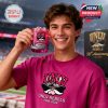 A happy UNLV Rebels fan holding a red anniversary whiskey glass inside a stadium environment!