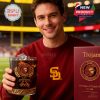 Close-up of USC Trojans 137-year whiskey glass held by a smiling fan in a stadium, highlighting ornate design and celebratory engraving.