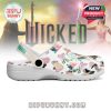 A left shoe from the Wicked Crocs series showcasing colorful symbols and the word Changed on the strap, placed in front of a themed Wicked backdrop!