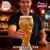 Man holding a large World Cup trophy shaped beer glass filled with beer in a bar setting.