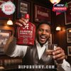 A person smiling and holding the Alabama Crimson Tide 135th Anniversary Edition bottle with a drink in hand in a bar.