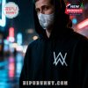Man wearing a black hoodie with Alan Walker's logo and mask, standing in a rainy cityscape.