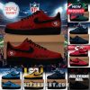 Multiple pairs of NFL team sneakers in different colors with logos and fan phrases displayed together in a football stadium setting.