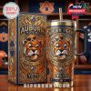 A Yeti tumbler showcasing the Auburn Tigers logo with a vivid tiger illustration, paired with an elaborate gift box. The design includes bold colors, ornate detailing, and a premium finish, emphasizing team pride and luxury!