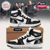 High-top black and white sneakers with custom name placement and celebrity-style printed autographs. Includes branding elements like “CORTIS” and a cardboard shoe box. Background features K-pop artists on a red carpet!