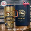 Commemorative gold Broncos tumbler and box set celebrating 25 years at Mile High Stadium displayed on a wooden table at the venue!