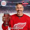 Smiling hockey fan holding a Detroit Red Wings YETI tumbler with the ice rink visible behind him!