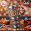 Close-up of Illinois Fighting Illini tumbler with raised team graphics and seasonal background.