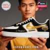 Black white and gold Iowa Hawkeyes championship sneaker held by a person showing detailed team branding and celebratory design!